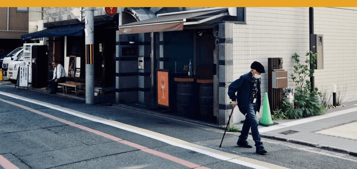 Man with cane walking down the street
